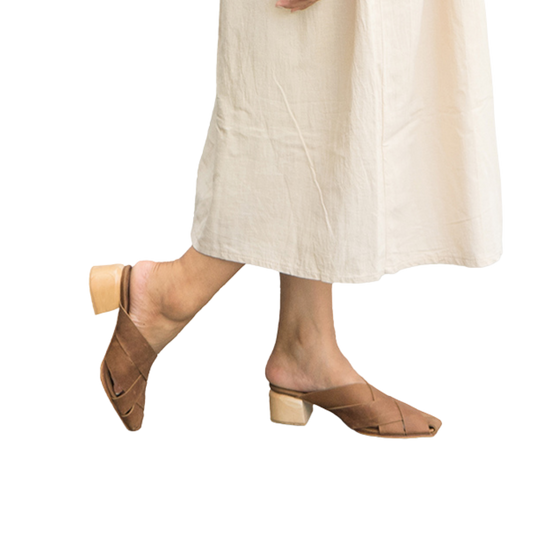 Heeled mules with wide woven leather upper by Seminyak Leather Bali, providing a custom fit. 5 cm wooden block heel in a natural finish. Crazyhorse cow leather sole with nonslip rubber for confident steps. A blend of style and comfort for elevated fashion.